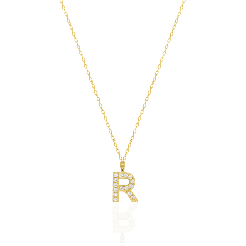 A goldtone initial necklace featuring a  letter pendant set with small clear stones, suspended from a delicate gold chain against a white background.