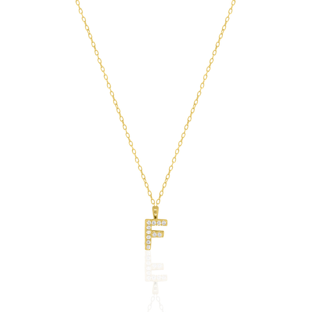 A goldtone initial necklace featuring a  letter pendant set with small clear stones, suspended from a delicate gold chain against a white background.