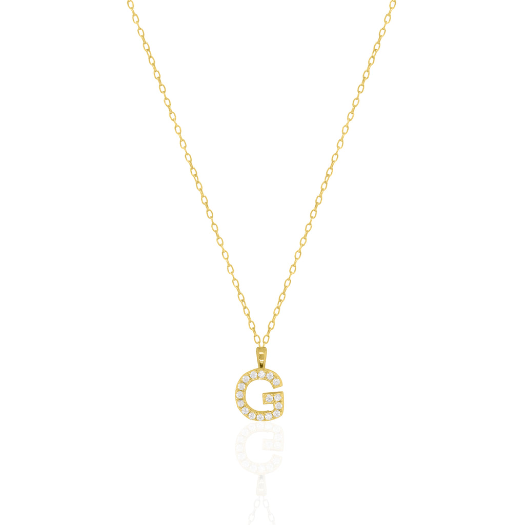 A goldtone initial necklace featuring a  letter pendant set with small clear stones, suspended from a delicate gold chain against a white background.