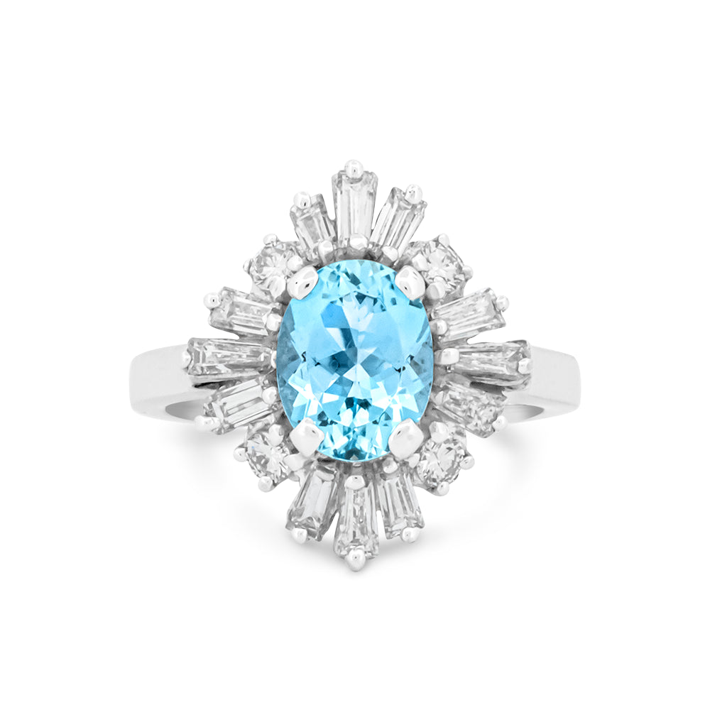 An oval-cut light aquamarine ring set in a white gold ring with baguette and round diamonds, shown on a plain white background.