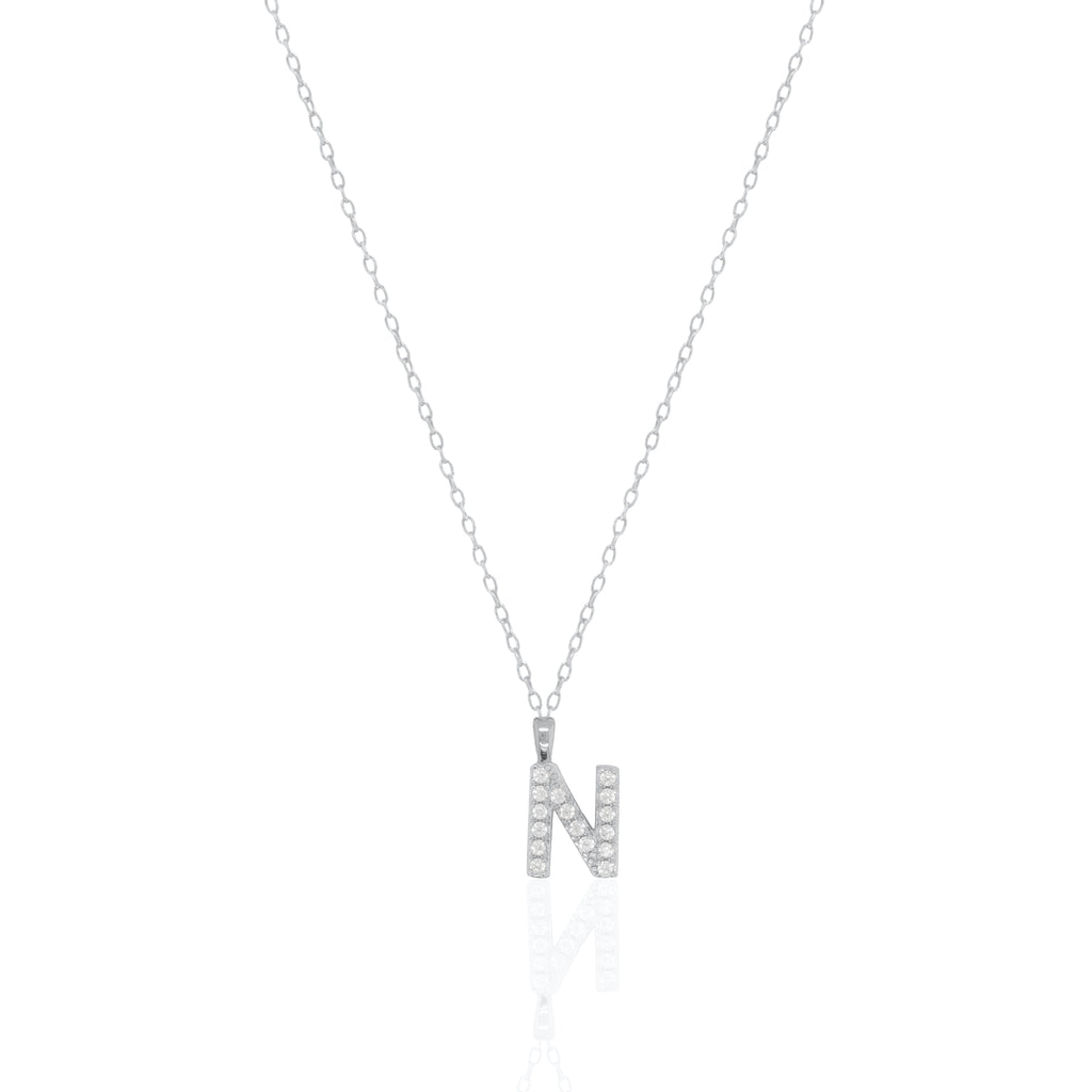 A silver initial necklace featuring a  letter pendant set with small clear stones, suspended from a delicate gold chain against a white background.