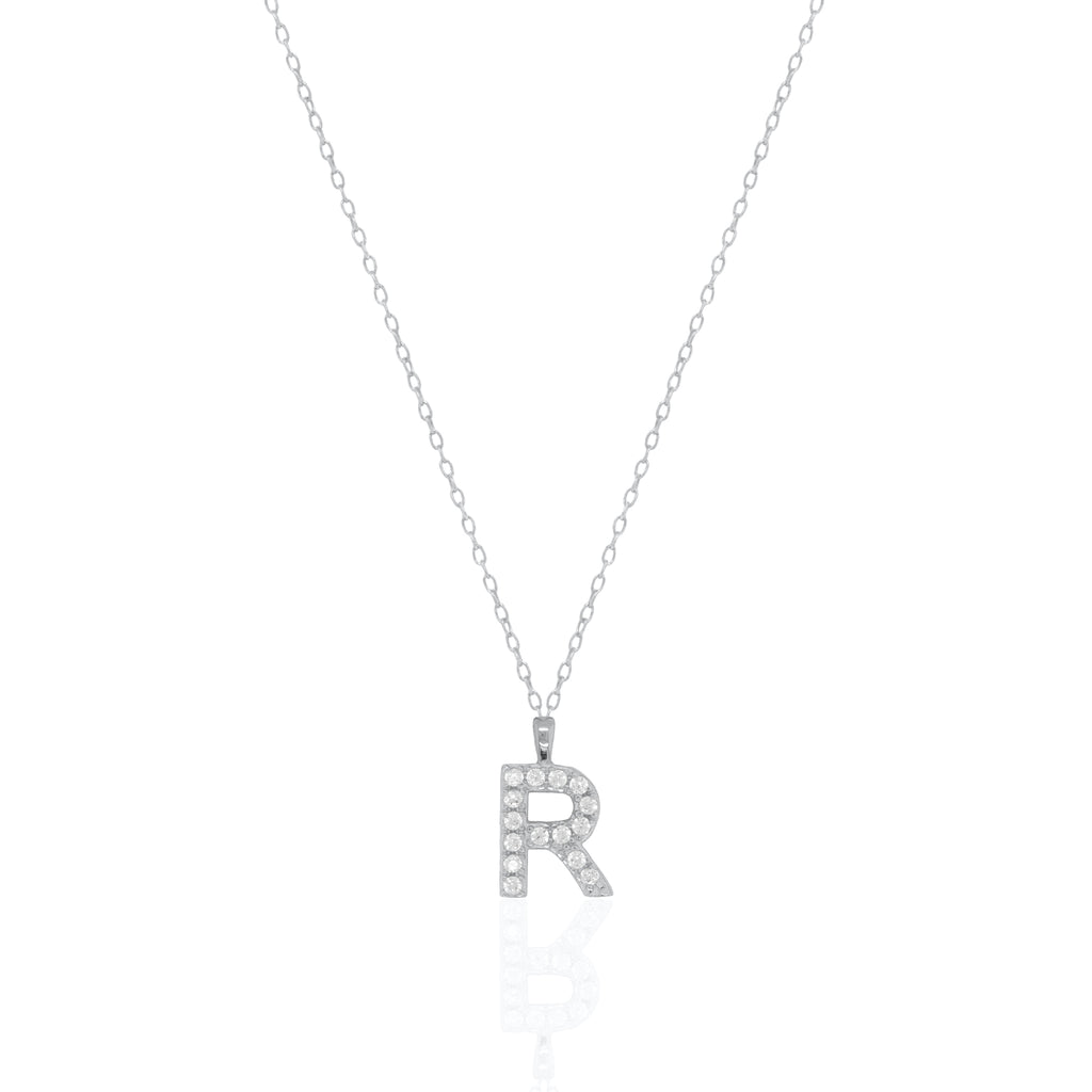 A silver initial necklace featuring a  letter pendant set with small clear stones, suspended from a delicate gold chain against a white background.