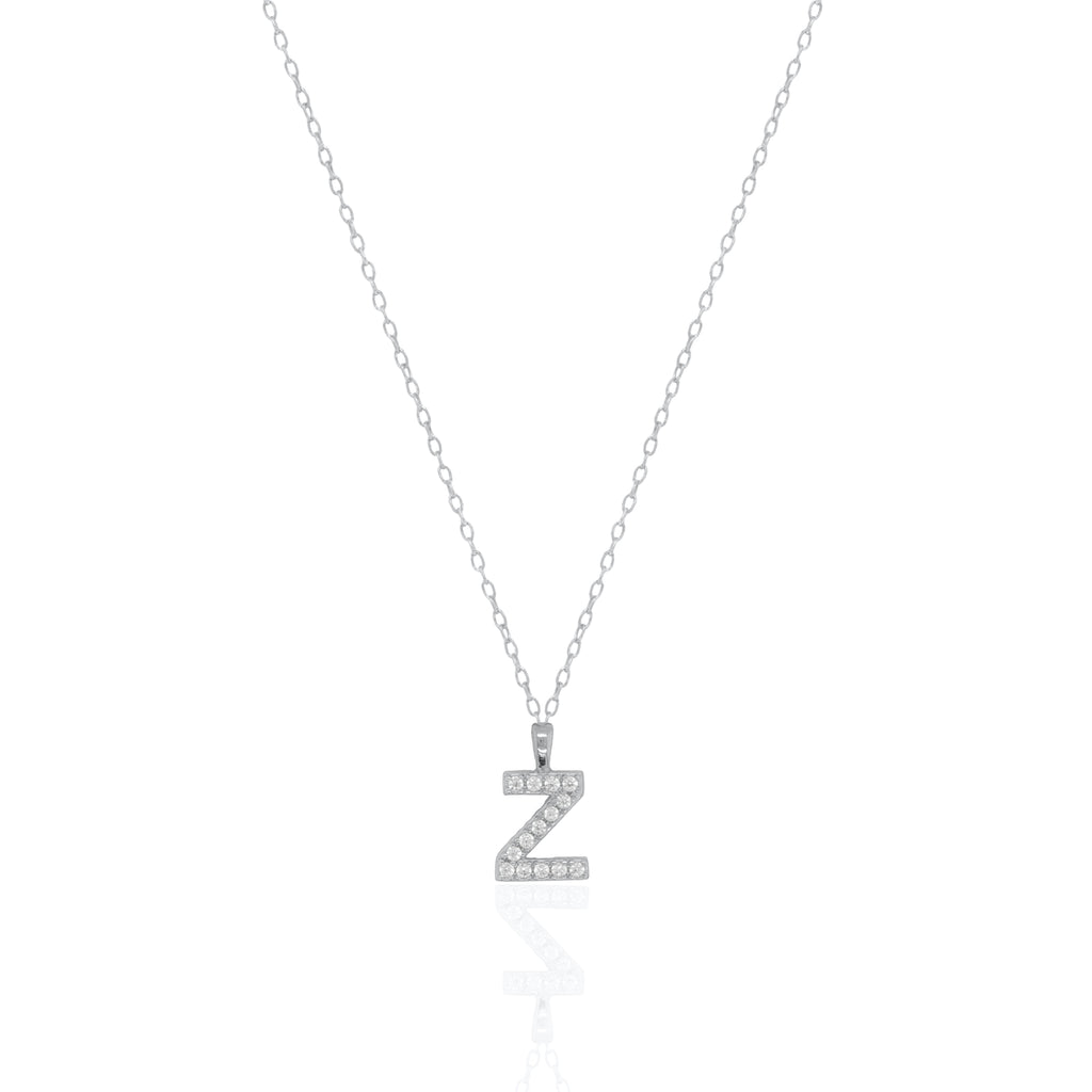 A silver initial necklace featuring a  letter pendant set with small clear stones, suspended from a delicate gold chain against a white background.